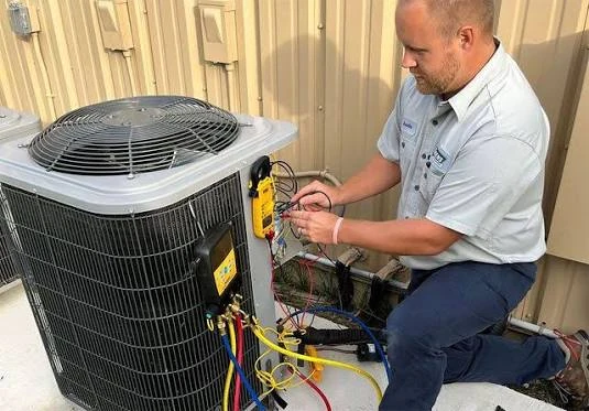 HVAC service professional testing an outdoor air conditioning system